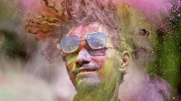A man covered in coloured powder shakes his head during Holi celebrations in Ahmedabad, India, March 17, 2022 - Sputnik International