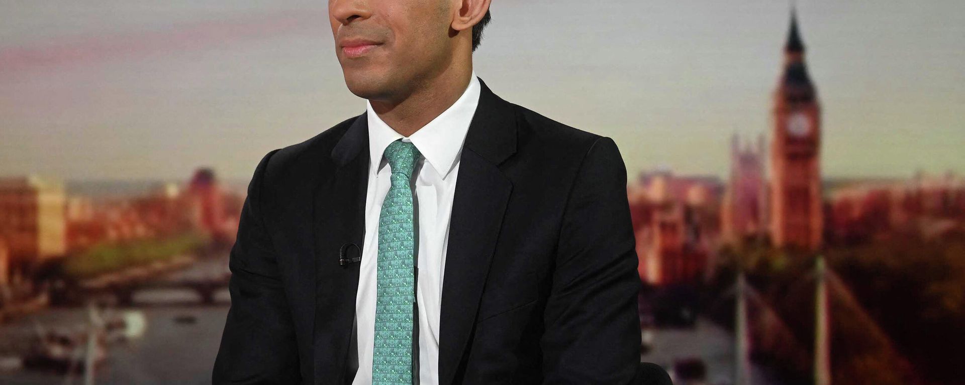 A handout picture released by the BBC, taken and received on March 20, 2022, shows Britain's Chancellor of the Exchequer Rishi Sunak appearing on the BBC's 'Sunday Morning' political television show with journalist Sophie Raworth - Sputnik International, 1920, 13.04.2022