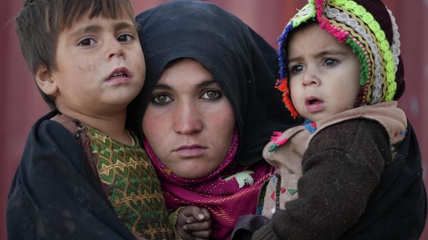 FILE - An Afghan woman holds her children as she waits for a consultation outside a makeshift clinic at a sprawling settlement of mud brick huts housing those displaced by war and drought near Herat, Afghanistan, Dec. 16, 2021. - Sputnik International