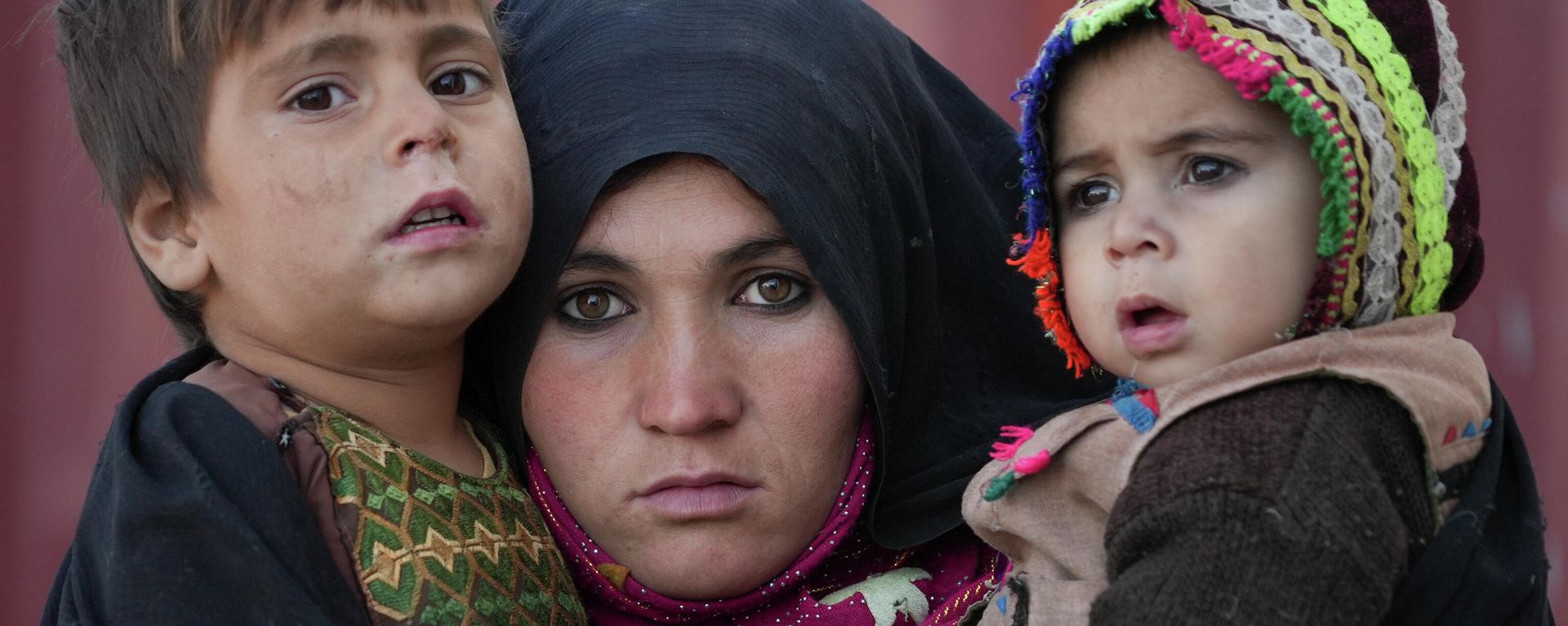 FILE - An Afghan woman holds her children as she waits for a consultation outside a makeshift clinic at a sprawling settlement of mud brick huts housing those displaced by war and drought near Herat, Afghanistan, Dec. 16, 2021. - Sputnik International, 1920, 25.04.2022