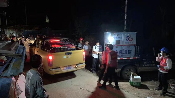 This photo taken on March 21, 2022 shows rescuers resting as they work at the site of a plane crash in Tengxian county, Wuzhou city, in China's southern Guangxi region. - Sputnik International