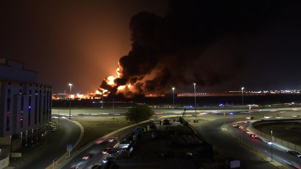 Cars drive on the roads as smoke and flames rise from a Saudi Aramco oil facility in Saudi Arabia's Red Sea coastal city of Jeddah, on March 25, 2022, following a reported Yemeni rebels attack - Sputnik International