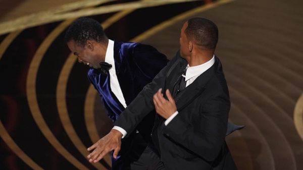 Will Smith, right, hits presenter Chris Rock on stage while presenting the award for best documentary feature at the Oscars on Sunday, March 27, 2022, at the Dolby Theatre in Los Angeles. - Sputnik International
