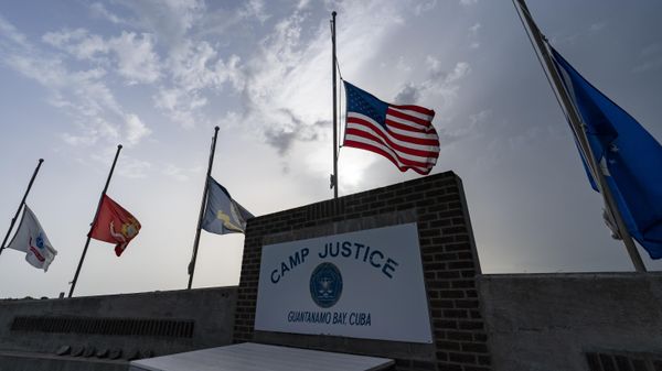In this photo reviewed by U.S. military officials, flags fly at half-staff at Camp Justice, Aug. 29, 2021, in Guantanamo Bay Naval Base, Cuba. The Defense Department says Sufiyan Barhoumi, an Algerian man imprisoned at the Guantanamo Bay detention center for nearly 20 years, has been released and sent back to his homeland. - Sputnik International