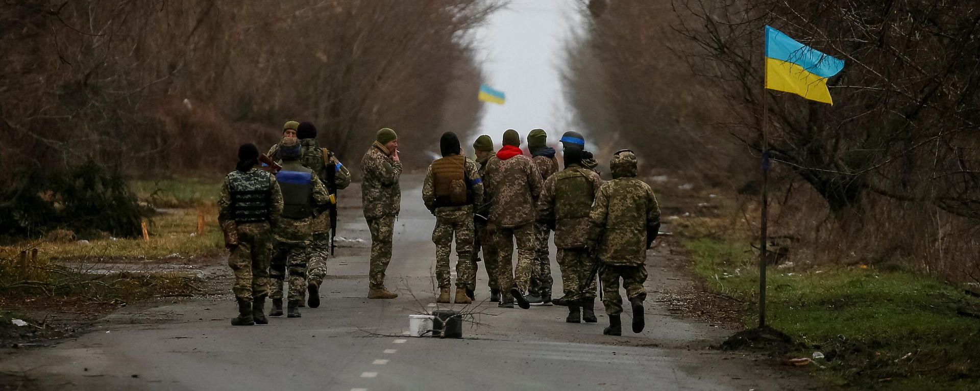 Ukrainian service members walk near a Ukrainian flag in the village of Kozarovychi, in Kyiv region, Ukraine April 2, 2022 - Sputnik International, 1920, 07.04.2022