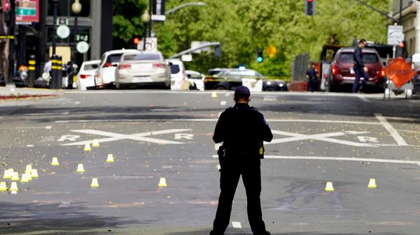 A Sacramento City Police Officer stands near a field of evidence markers after a mass shooting In Sacramento, Calif. April 3, 2022. - Sputnik International