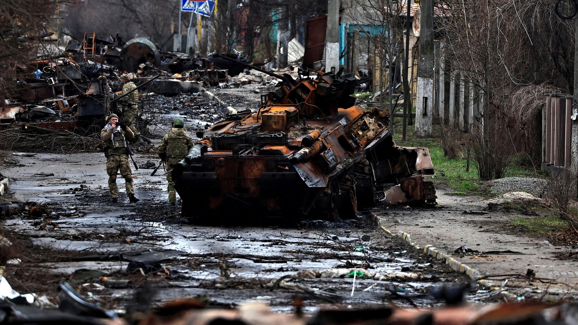 A soldier takes a photograph of his comrade as he poses beside a destroyed Russian tank and armoured vehicles in Bucha, Kiev region, Ukraine April 2, 2022 - Sputnik International, 1920, 04.04.2022