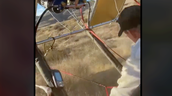 Screenshot capture the moment in which a hot air balloon came crashing down in an area near Perris, California, after undergoing technical difficulties prompted by strong winds.  - Sputnik International