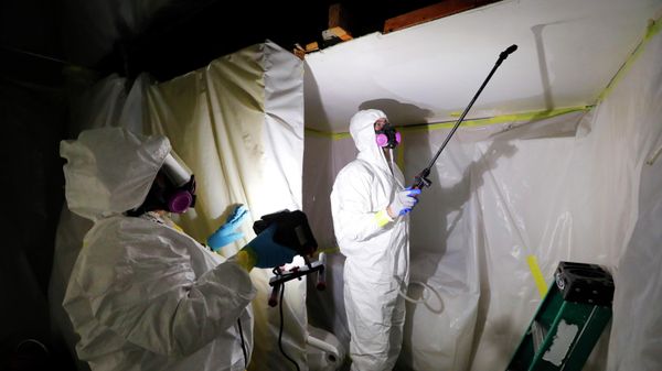 Asbestos Removal Technologies Inc., job superintendent Ryan Laitila, right, sprays amended water as job forman Megan Eberhart holds a light during asbestos abatement in Howell, Mich., Oct. 18, 2017. - Sputnik International