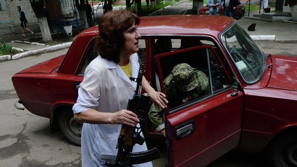 Медицинский работник помогает раненному во время боестолкновений в районе Семеновки на окраине Славянска бойцу ополчения Донбасса выйти из автомобиля, на котором его привезли в больницу местные жители - Sputnik International