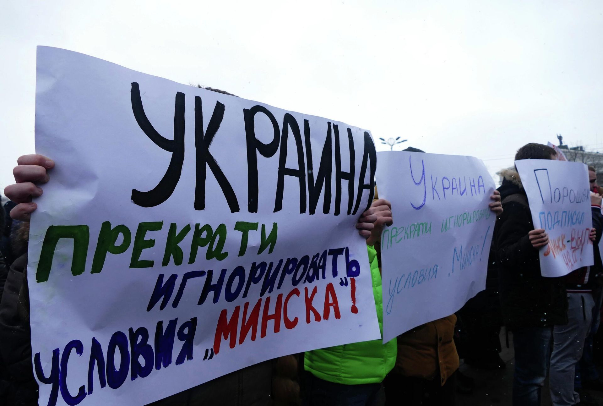 Donetsk residents at a meeting hold up signs appealing to world leaders to end the Ukraine crisis. 2017. Leftmost and middle signs read Ukraine: Stop ignoring the terms of Minsk! - Sputnik International, 1920, 16.04.2022
