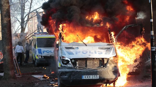 Police vans are on fire during a counter-protest in the park Sveaparken in Orebro, south-centre Sweden - Sputnik International
