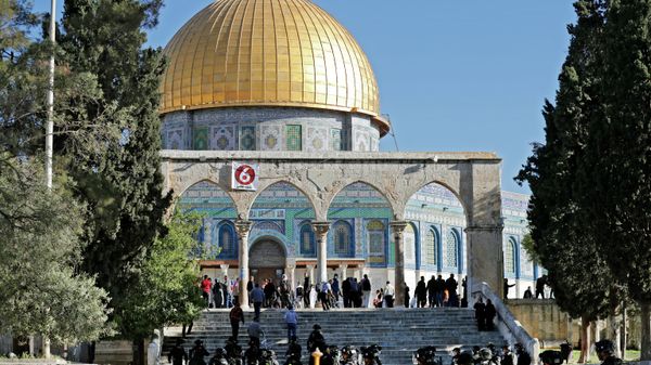 Israeli security forces patrol and Palestinians face each other in front of the Dome of the Rock mosque during clashes at Jerusalem's Al-Aqsa mosque compound, on April 15, 2022 - Sputnik International