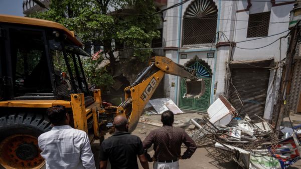 Officials watch as a bulldozer razes the wall of a local mosque in the area that saw communal violence during a Hindu religious procession on Saturday, in New Delhi's northwest Jahangirpuri neighborhood, in New Delhi, India, Wednesday, April 20, 2022.  - Sputnik International