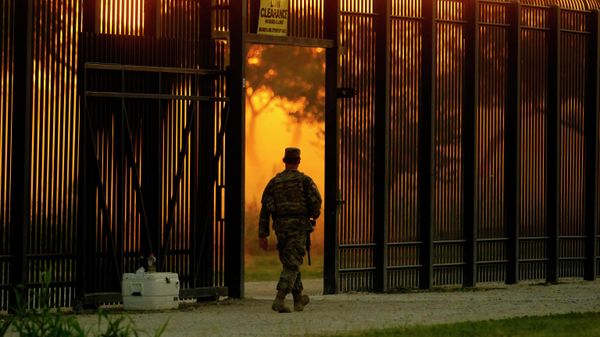 A National Guardsman stands guard at a fence that runs along the Rio Grande near the International bridge, Friday, Sept. 17, 2021, in Del Rio, Texas - Sputnik International