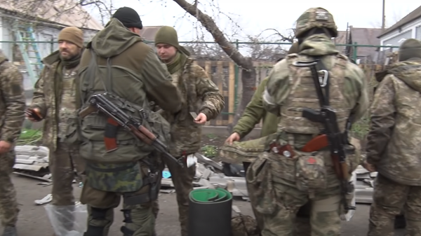 Surrendered Ukrainian forces being checked for ID by Russian and Donetsk People's Republic Forces. Screengrab of DPR Interior Ministry video. - Sputnik International