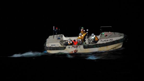 In this photo released by the 10th Regional Japan Coast Guard Headquarters, a Filipino crewmember, red jacket, of a Panamanian cargo ship is rescued by Japanese Coast Guard members in the waters off the Amami Oshima, Japan Wednesday, Sept. 2, 2020. - Sputnik International