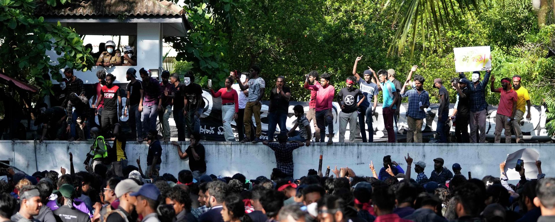 Sri Lankan university students shouts slogans against government during a protest over the country’s worst economic crisis in decades as they climb the wall of the residence of prime minister Mahinda Rajapaksa in Colombo, Sri Lanka - Sputnik International, 1920, 25.04.2022