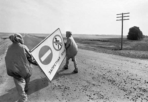 Clean-up workers carrying a sign that says "Restricted Area". - Sputnik International