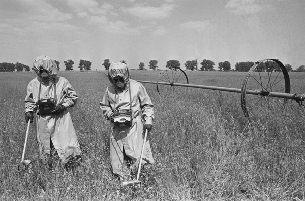 Dosimetrists check radiation levels in the field near the site of the Chernobyl nuclear disaster. - Sputnik International
