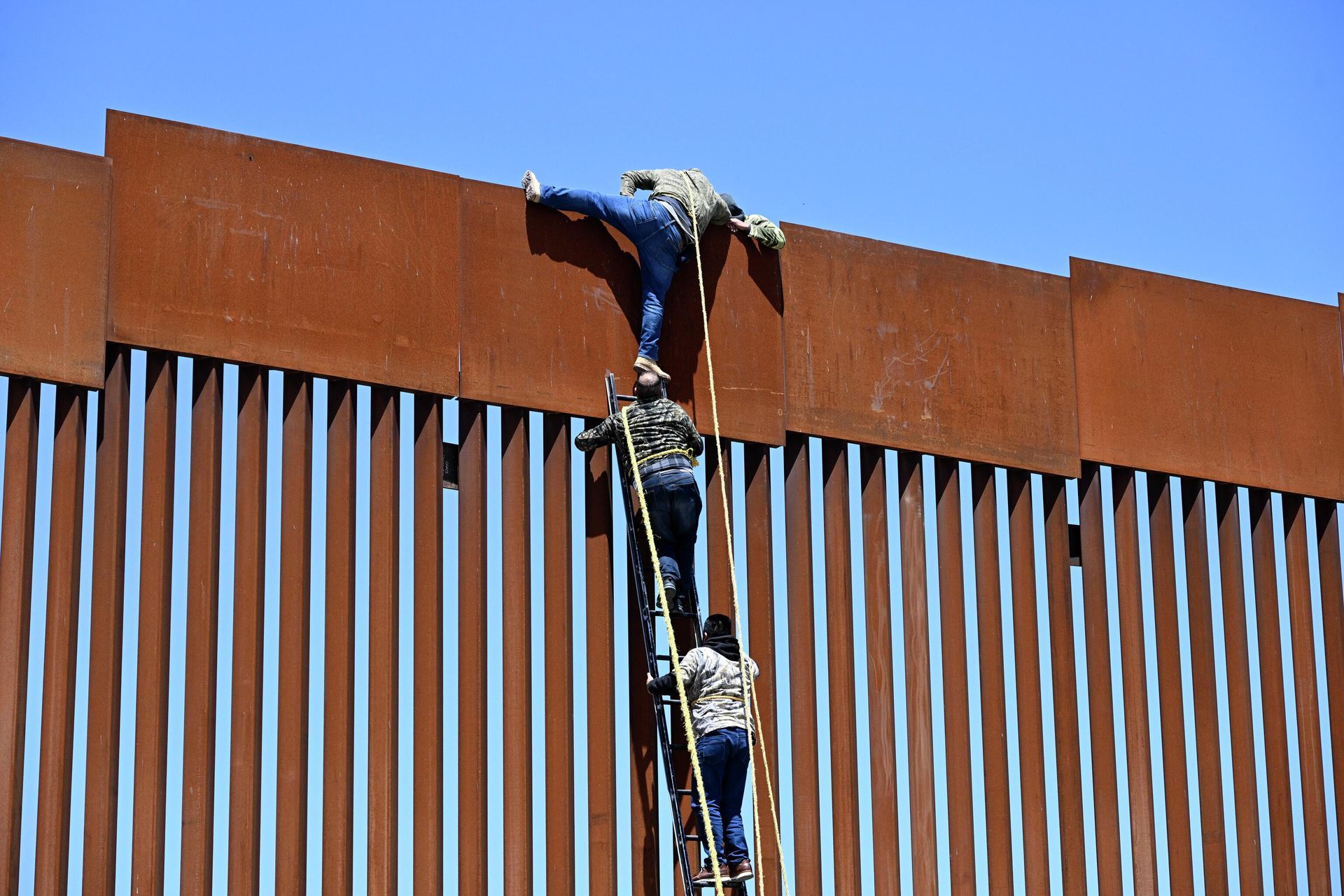 People use a ladder to scale the border fence at the US/Mexico border in Tecate, Mexico, Thursday, April 21, 2022. The men used the ropes to lower themselves down on the United States side. People use a ladder to scale the border fence at the US/Mexico border in Tecate, Mexico, Thursday, April 21, 2022. The men used the ropes to lower themselves down on the United States side. - Sputnik International, 1920, 16.09.2022