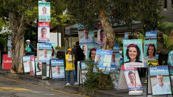 A volunteer stands amongst billboards for candidates outside a polling station in Sydney, Australia, Monday, May 9, 2022. - Sputnik International