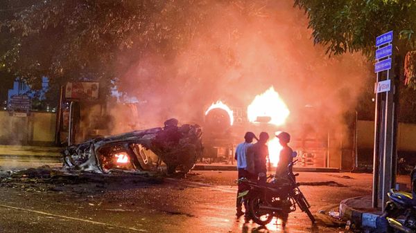 A vehicle belonging to the security personnel and a bus set alight is pictured near Sri Lanka's outgoing Prime Minister Mahinda Rajapaksa's official residence in Colombo May 9, 2022. - Sputnik International