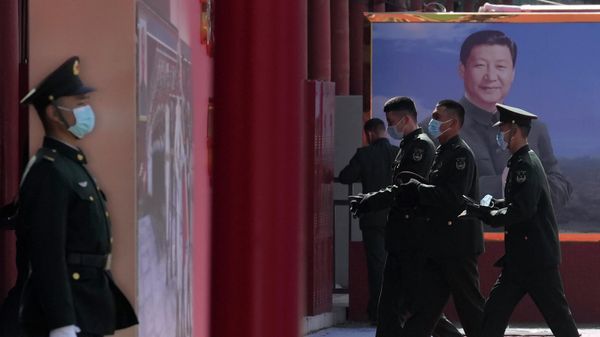 Chinese military personnel pass by a board displaying a photo of Chinese President Xi Jinping on March 4, 2022, in Beijing.  - Sputnik International