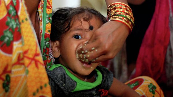 A mother feeds her child as Indian volunteers distribute relief food to cyclone evacuated people in a relief camp at Chatrapur, about 180 kilometers south of eastern city Bhubaneswar on October 12, 2013 - Sputnik International