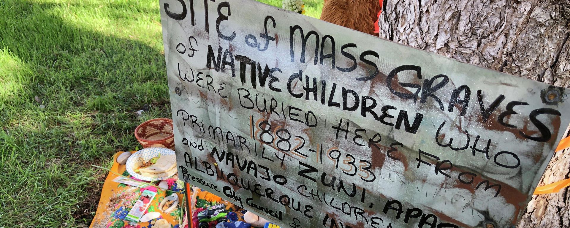 A makeshift memorial for the dozens of Indigenous children who died more than a century ago while attending a boarding school that was once located nearby is displayed under a tree at a public park in Albuquerque, N.M., on  July 1, 2021.  - Sputnik International, 1920, 11.05.2022