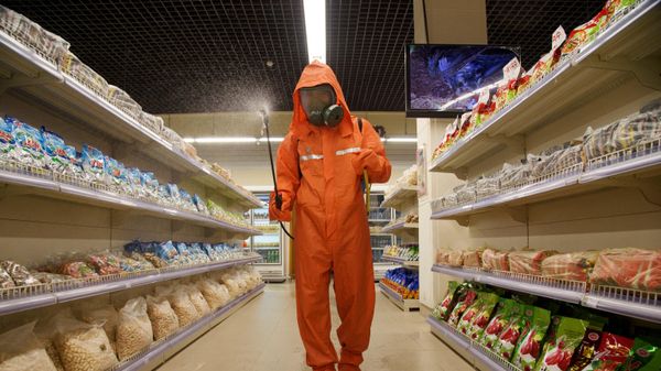 In this file picture taken on September 27, 2021, a health official sprays disinfectant as part of preventative measures against Covid-19, in the Daesong Department Store in Pyongyang. - Sputnik International