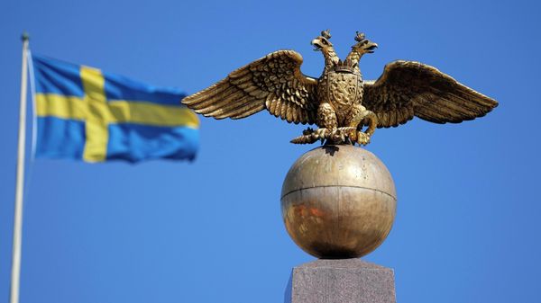 A Russian Imperial double-headed eagle is seen in front of a Sweden flag on the Czarina's Stone in the Market Square, in Helsinki, Finland, Friday, May 13, 2022. - Sputnik International