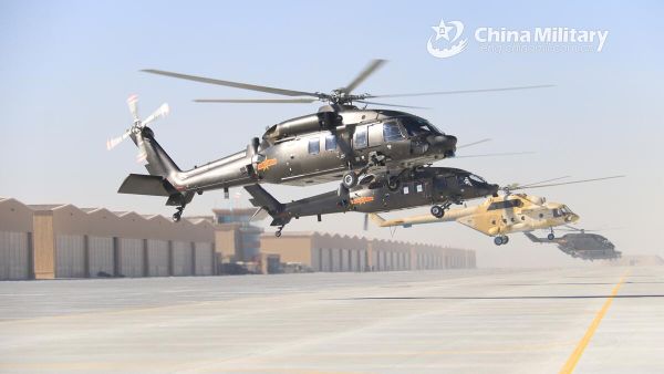 Pilots assigned to an army aviation brigade under the PLA 76th Group Army maintain their helicopters in nearly motionless flight over a reference point at an ultra-low altitude before lifting off for a flight training exercise on January 5, 2022 - Sputnik International