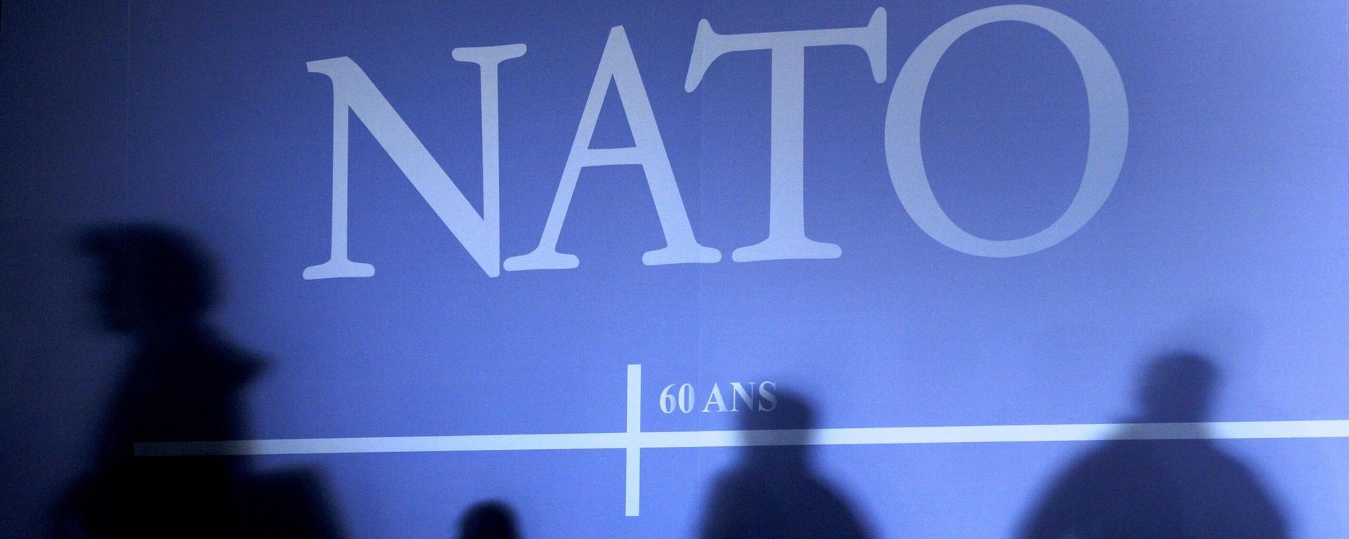 This April 2, 2009 file photo shows shadows cast on a wall decorated with the NATO logo and flags of NATO countries in Strasbourg, eastern France, before the start of the NATO summit which marked the organisation's 60th anniversary.  - Sputnik International, 1920, 18.03.2023