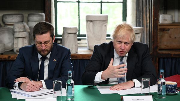 Britain's Prime Minister Boris Johnson (R), flanked by Britain's Cabinet Secretary and Head of the Civil Service Simon Case, chairs a Cabinet meeting at a pottery in Stoke-on-Trent, central England, on May 12, 2022 - Sputnik International