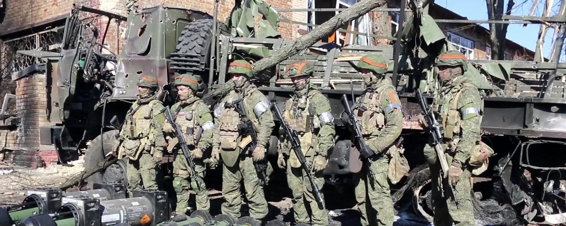 In this handout video grab released by the Russian Defence Ministry, Russian servicemen are pictured by military equipment captured by Russian troops during Russia's military operation in Ukraine, near the village of Huta-Mezhyhirska, in Ukraine - Sputnik International, 1920, 25.05.2022