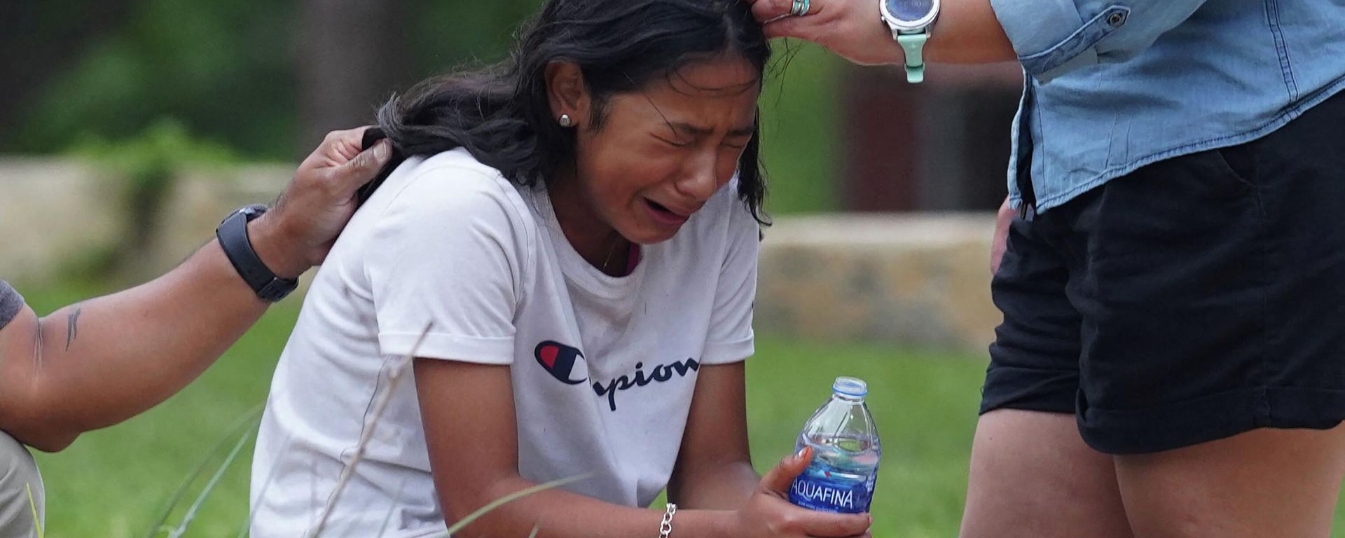 A girl cries, comforted by two adults, outside the Willie de Leon Civic Center where grief counseling will be offered in Uvalde, Texas, on May 24, 2022. - A teenage gunman killed 18 young children in a shooting at an elementary school in Texas on Tuesday, in the deadliest US school shooting in years. - Sputnik International, 1920, 27.05.2022
