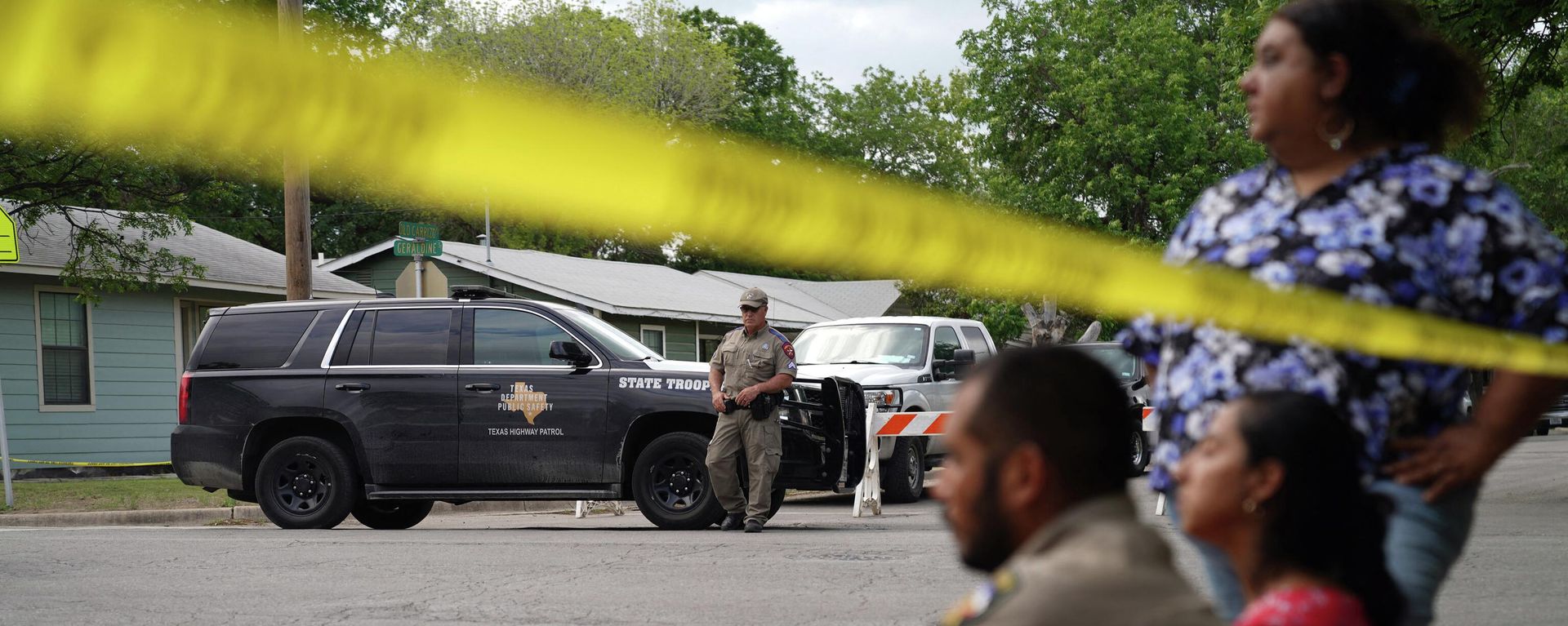 People sit on the curb outside of Robb Elementary School as State troopers guard the area in Uvalde, Texas, on May 24, 2022 - Sputnik International, 1920, 01.06.2022