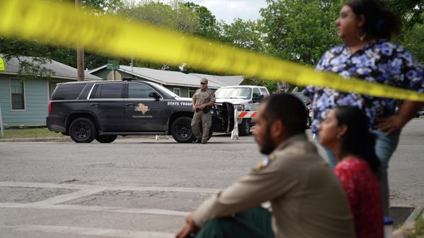 People sit on the curb outside of Robb Elementary School as State troopers guard the area in Uvalde, Texas, on May 24, 2022 - Sputnik International
