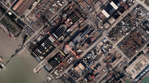 China's Type 003 aircraft carrier under construction at Jiangnan Shipyard in Shanghai, in early 2022. A large segment of another ship sits between its drydock and the Yellow River, blocking view of its construction from the water. - Sputnik International