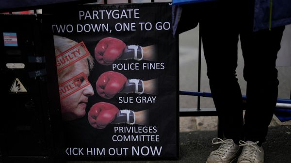 An anti-Boris Johnson, anti-Brexit protester stands next to a placard across the street from the Houses of Parliament on the edge of Parliament Square, in London, Wednesday, May 25, 2022 - Sputnik International