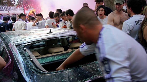 A man puts his hand inside a smashed car window outside the Santiago Bernabeu stadium before fans entered to watch the Champions League soccer final on big screens inside the stadium in Madrid, Spain, Saturday, May 28, 2022 - Sputnik International