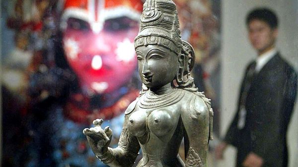 A man walks past a 14th century bronze sculpture of Indian love goddess Parvati, 27 February 2003, at an exhibition in Beijing's Millenium Monument - Sputnik International