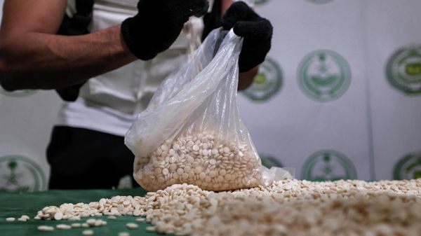 An officer of the Directorate of Narcotics Control of Saudi Arabia's Interior Ministry empties a bag of tablets of captagon (Fenethylline) seized during a special operation and presented before AFP afterwards in the Red Sea coastal city of Jeddah on March 1, 2022.  - Sputnik International