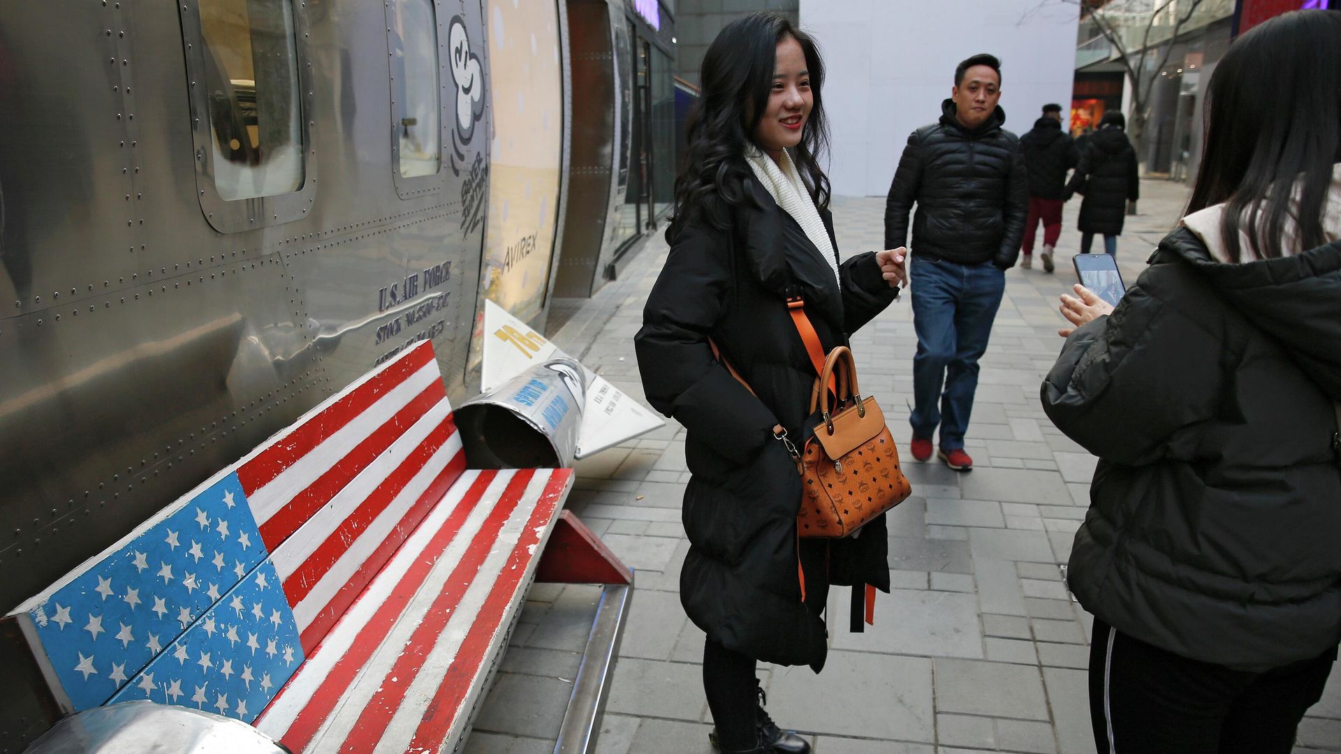 In this Sunday, Jan. 6, 2019, photo, Chinese shoppers spend their time next to a bench painted with the U.S. flag at the capital city's popular shopping mall in Beijing - Sputnik International, 1920, 14.04.2025
