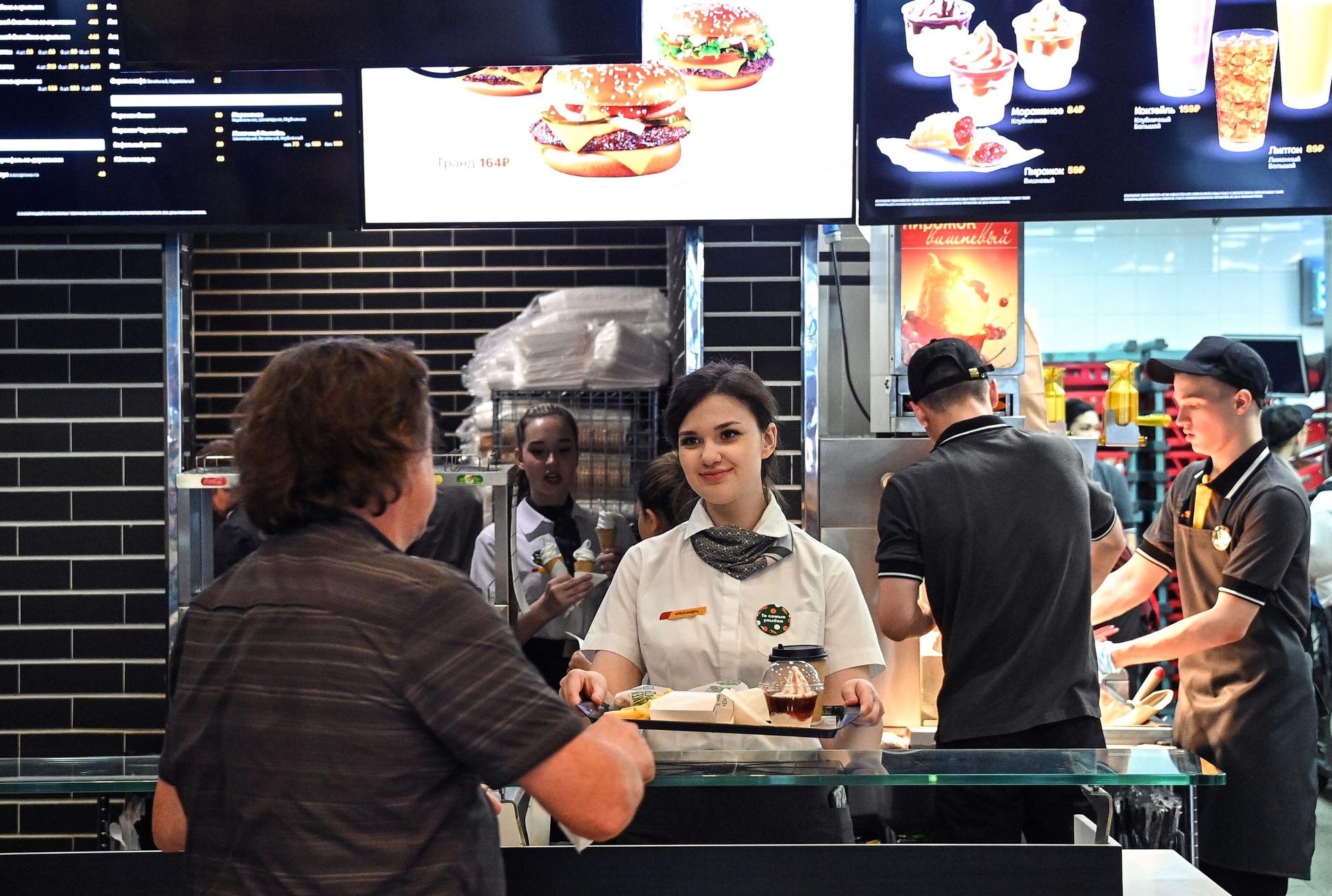 An employee gives an order to a customer in a joint of the newly opened fast food restaurant chain on Bolshaya Bronnaya Street in Moscow, Russia. The new chain of restaurants based on McDonald's is going to be called Vkusno i tochka (Delicious and that's it!). An employee gives an order to a customer in a joint of the newly opened fast food restaurant chain on Bolshaya Bronnaya Street in Moscow, Russia. The new chain of restaurants based on McDonald's is going to be called Vkusno i tochka (Delicious and that's it!). - Sputnik International, 1920, 12.06.2022