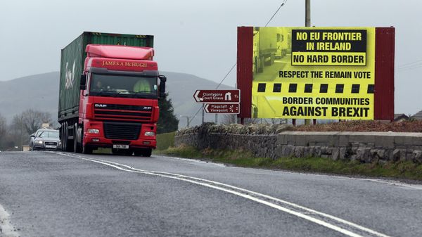 Trafic crosses the border into Northern Ireland from the Irish Republic next to a poster protesting against a hard brexit near Dundalk on January 30, 2017 - Sputnik International