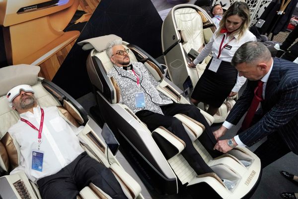 Russian pop singer Philipp Kirkorov, centre, tests a massage chair at the St. Petersburg International Economic Forum. - Sputnik International