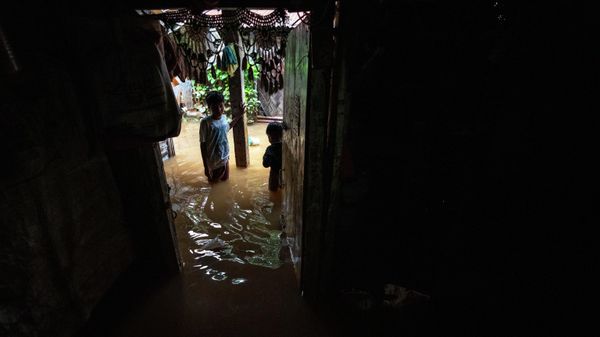 Children stand outside a house surrounded by water after continuous rainfall in Gauhati, India, Wednesday, June 15, 2022 - Sputnik International