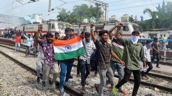 Protesters shout slogans after setting a train on fire during a demonstration against the government's new 'Agnipath' recruitment scheme for the army, navy, and air forces at a railway station in Secunderabad on June 17, 2022 - Sputnik International
